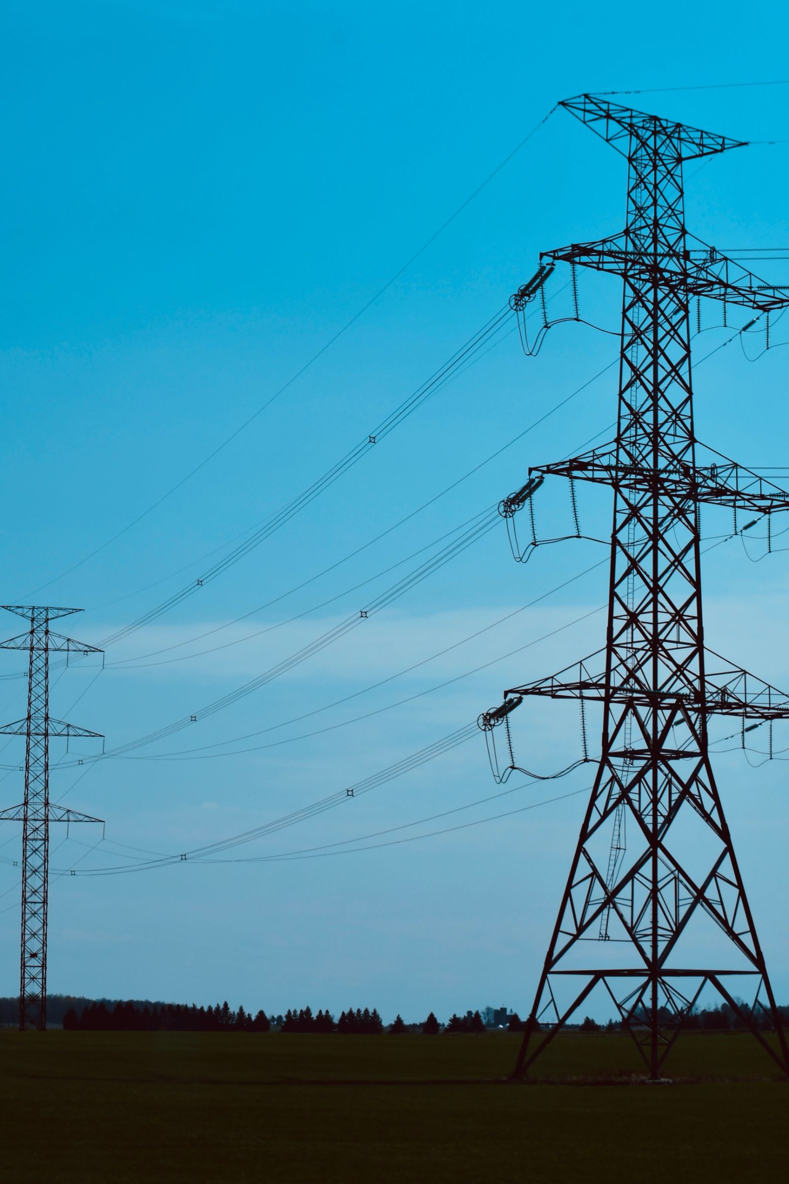 Electricity transmission pylons against a blue sky